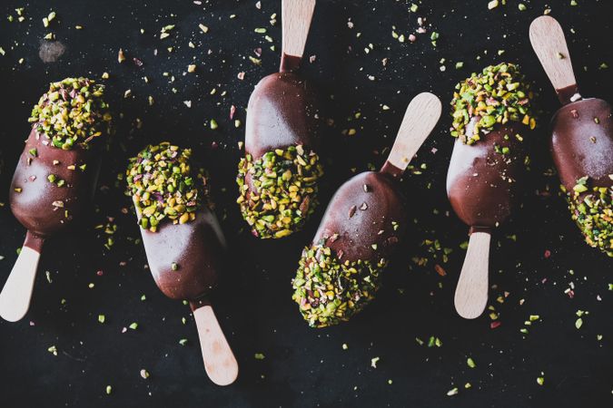 Ice cream chocolate pistachio popsicles, dark background, top view, dark up