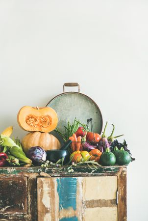Fresh autumnal produce on kitchen counter, with halved squash and grey tray with copy space