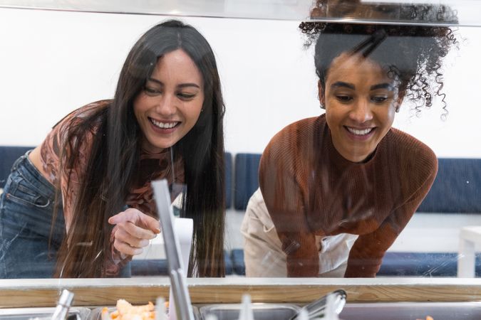 Multiethnic women choosing food in restaurant