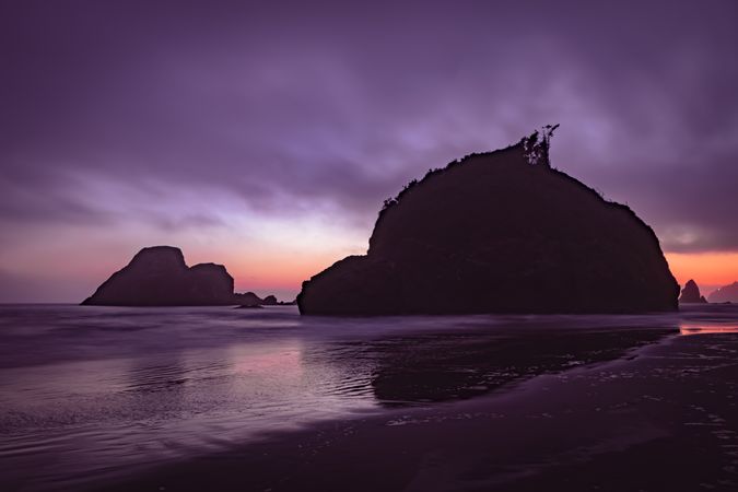 Two large rocks under cloudy purple hued sky