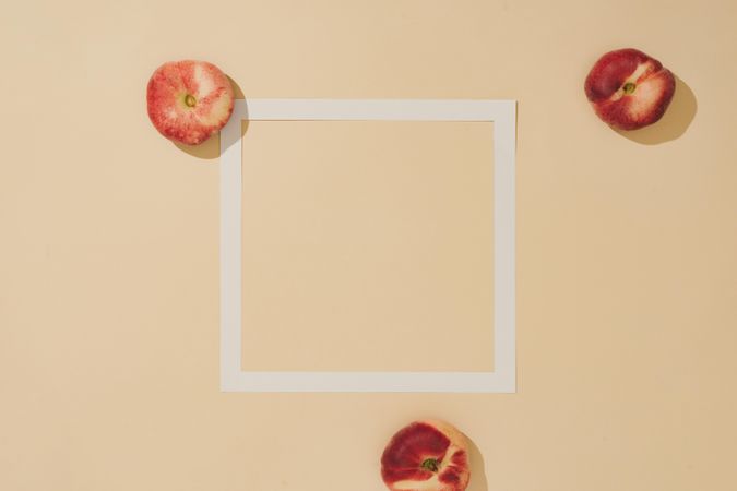 Minimal sunlit fruit composition with sand color background and sharp shadows