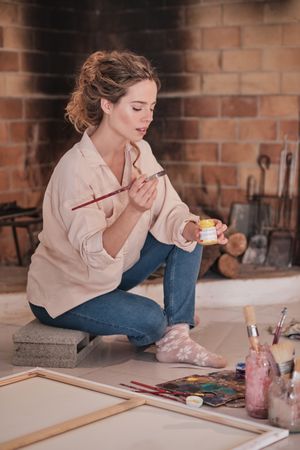 Young woman painting in creative workspace