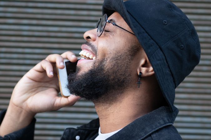 Happy hipster man getting good news during phone call