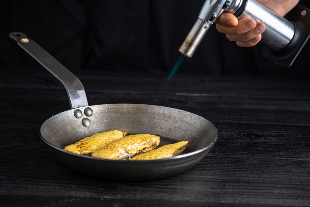 Person cooking endive with burner in pan