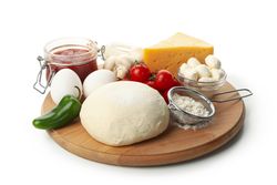 Dough and ingredients for cooking pizza isolated on blank background