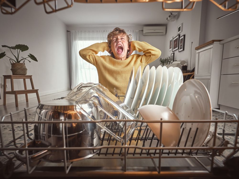 Boy screaming near dishwasher with kitchenware