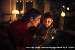 Mother and son with candy cane inside their house at Christmas 5qo8Yb