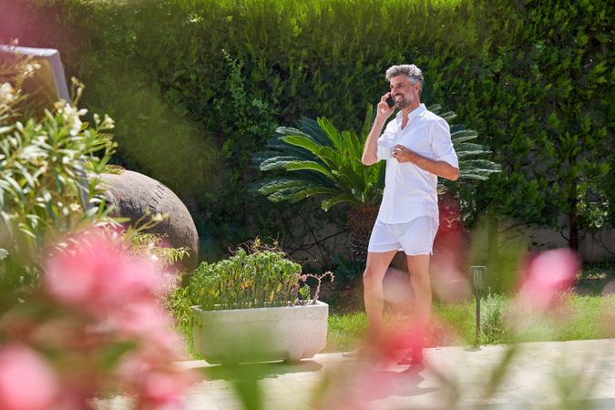 Mature man talking on mobile phone in garden