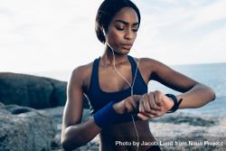 Fit female runner using smart watch to monitor her performance 48JPj0