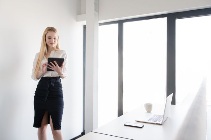 Smiling woman using tablet in office