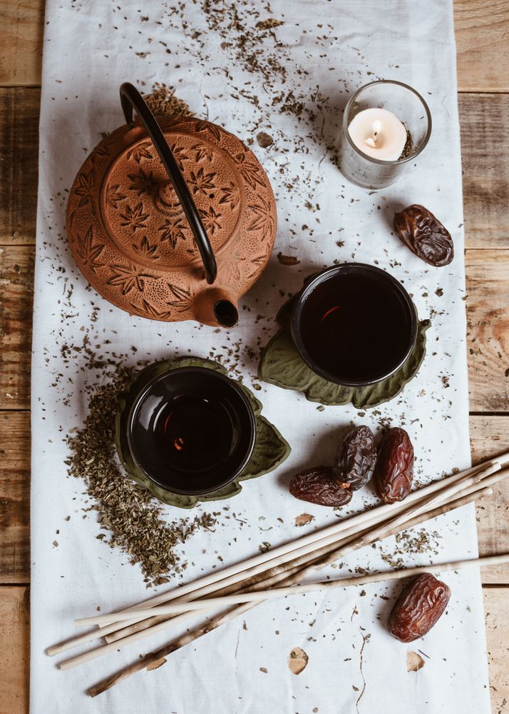 Aromatic tea dates and clay teapot on table