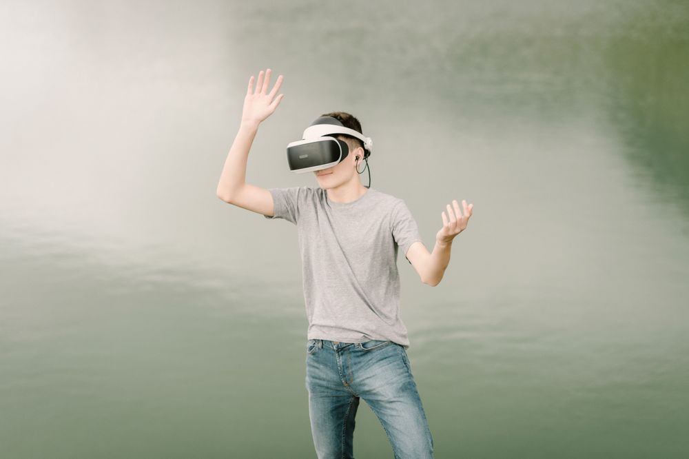 Young teenager with virtual reality glasses outdoors