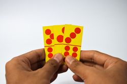 Hands holding three domino cards