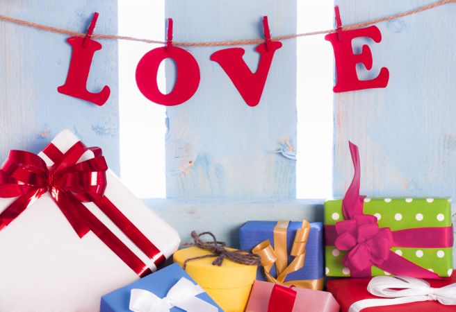 The word “love” spelled out hanging as a banner with colorful presents below