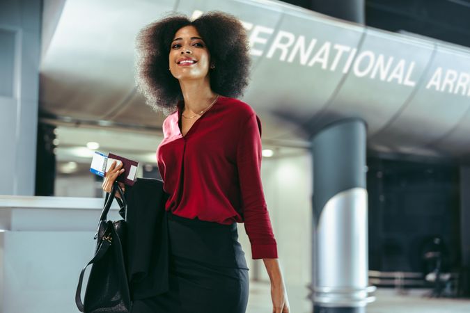 Female business traveler with luggage on transit at airport terminal