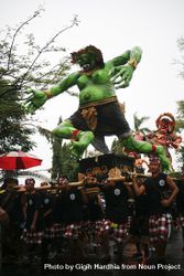 Green statue being carried by men during Hindu prayer ceremony 4ZoeAb