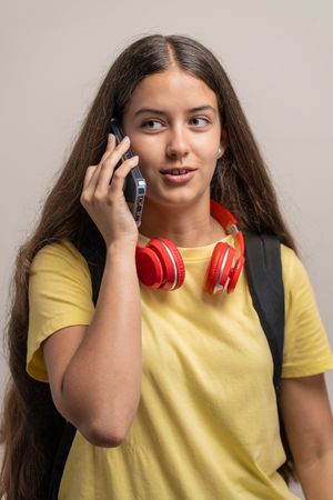 A young female student talking on her mobile phone in a studio.