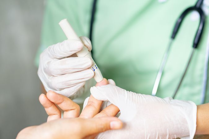 Nurse pinching a patient's finger