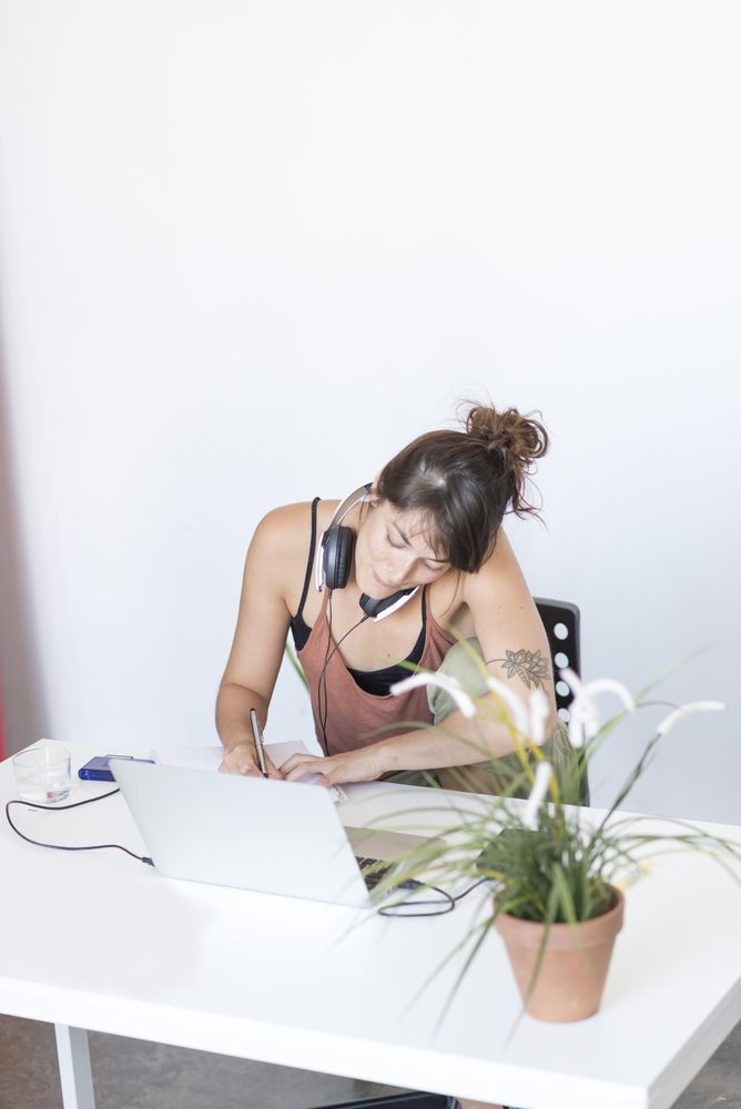 Female writing on paper in home office