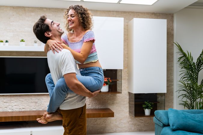Laughing couple embracing at apartment