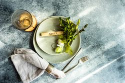 Easter concept with branch and green decorative eggs on ceramic plates with copy space