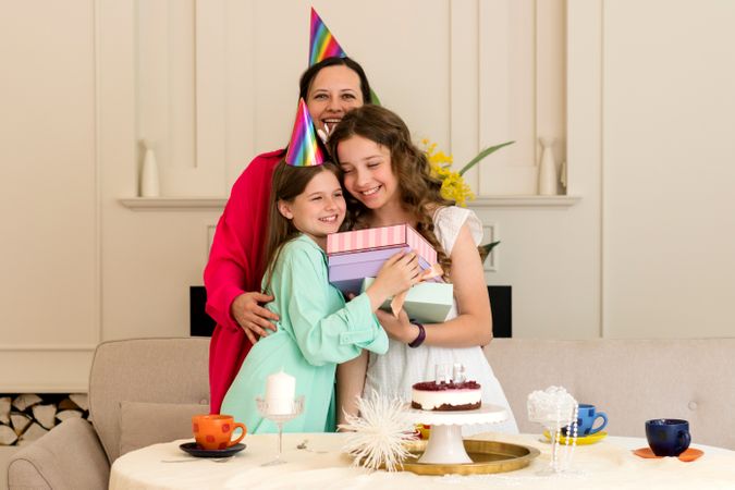 Birthday girl embraces her mother and sister