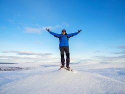 Man with arms raised standing in the snow