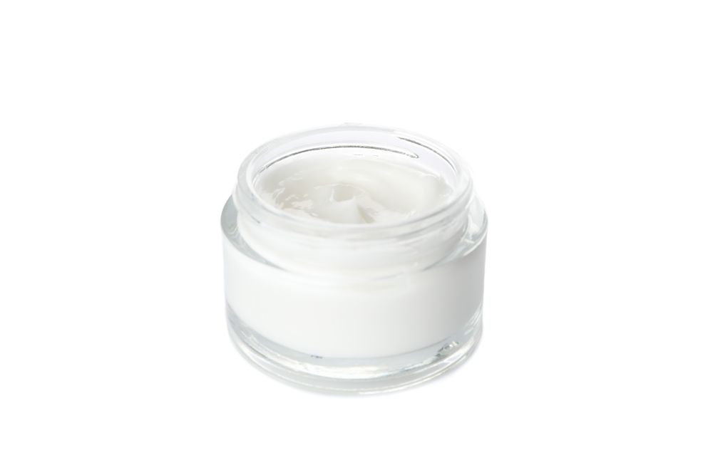Cosmetic cream in glass jar isolated on blank background