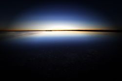 Tranquil blue water surface in dark sunset