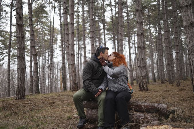 Emotional connection between a man and woman in a forest. Sharing a kiss on Valentines Day.