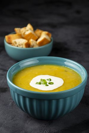 Bowl with pumpkin soup on the table.