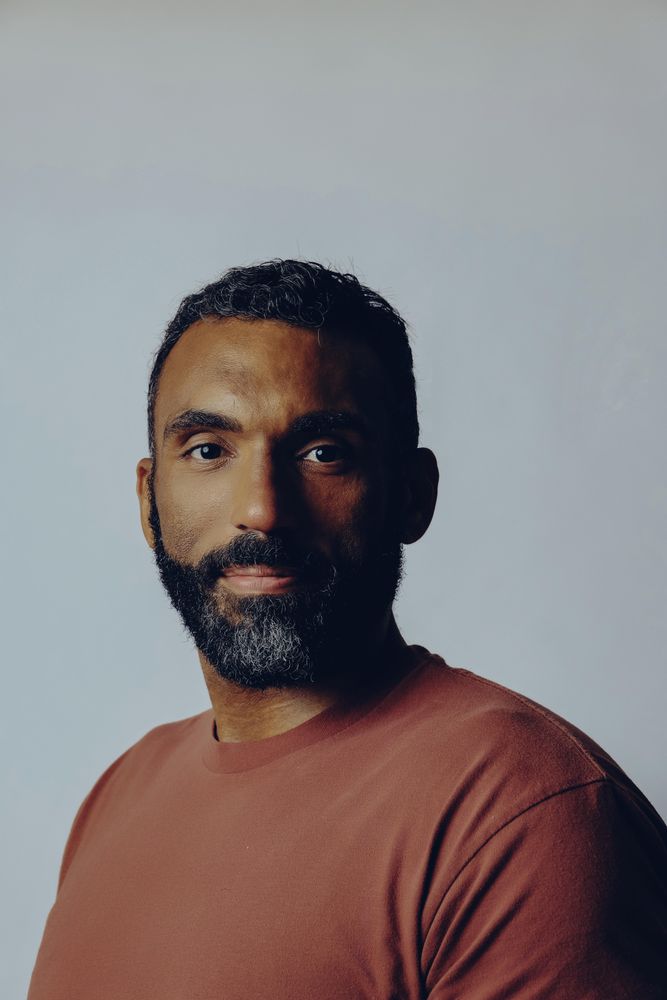 Portrait of proud Black male in grey studio, vertical