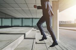Man in business attire running up the stairs