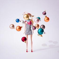 Doll in silver glittering dress with colorful Christmas baubles decoration