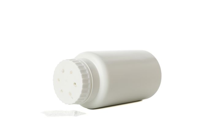 Blank bottle of talcum powder isolated on light background