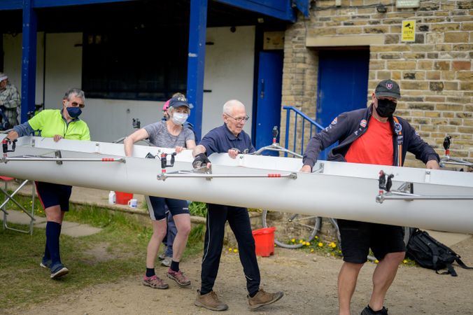 Older people walking boat to the river for rowing
