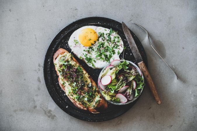 Avocado toast on sourdough bread with herbs and sprouts