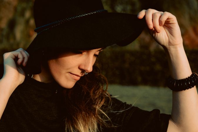 Stylish young woman in felt hat outdoors
