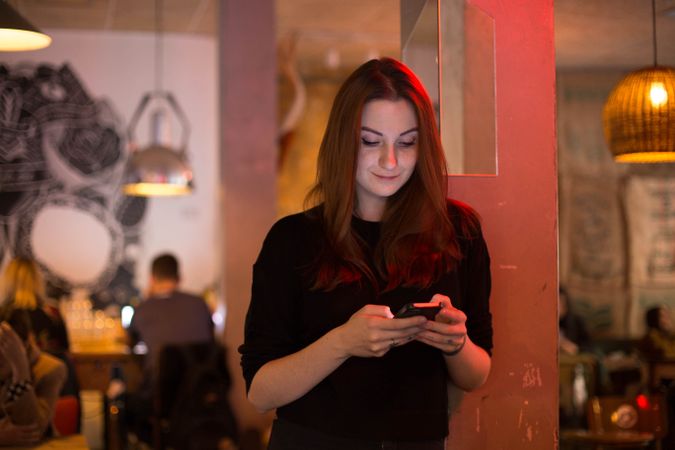 Woman checking phone in cafe
