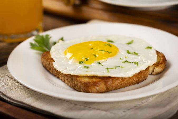 Breakfast with juice, coffee and toast with fried egg.