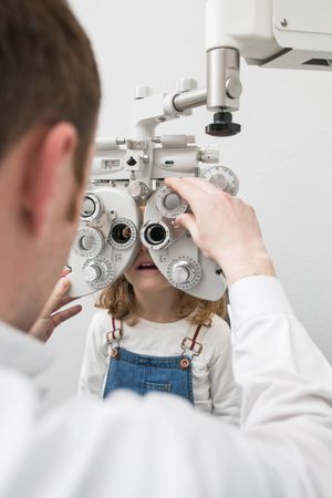Optician testing a girl's eyes