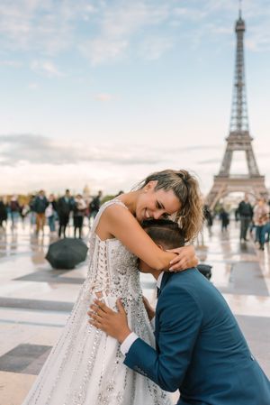 Bridegroom kneeling and kissing bride