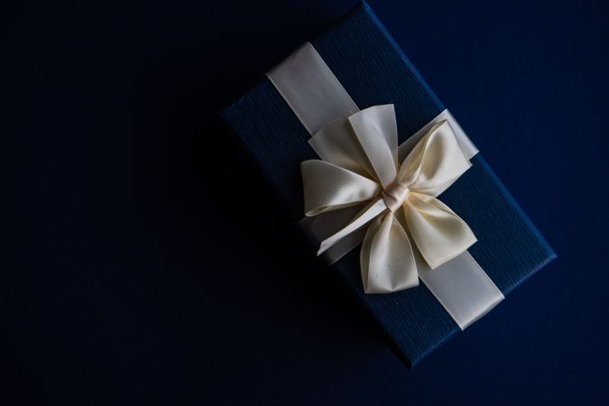 Top view of blue giftbox with cream ribbon