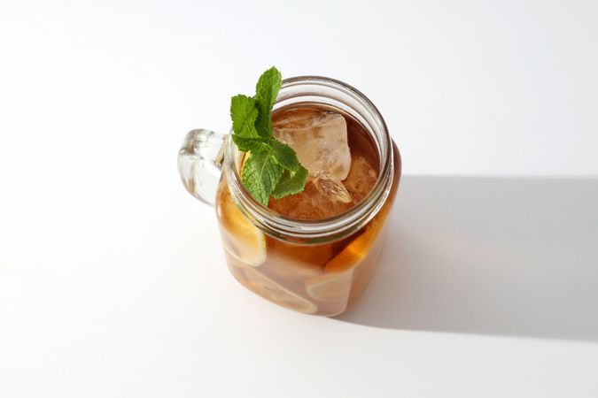 A glass of delicious cold tea on a plain background