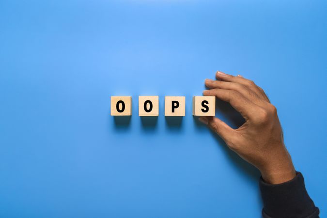 male put wooden blocks with oops words isolated on wooden background