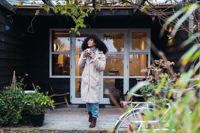 Smiling Black woman with cup of coffee