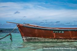 Side of red boat in clear tropical waters 0ypoqb