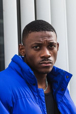 Black stylish man in warm jacket on street