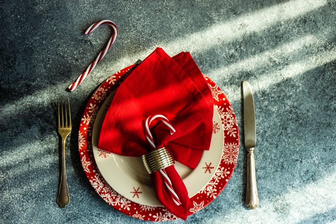 Christmas dinner concept with seasonal red plate and candy canes