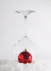 Holiday abstract concept of bauble in wine glass